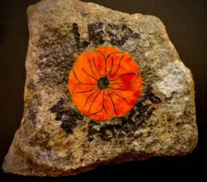 Remember to work for peace with a poppy stone made with a rough stone.